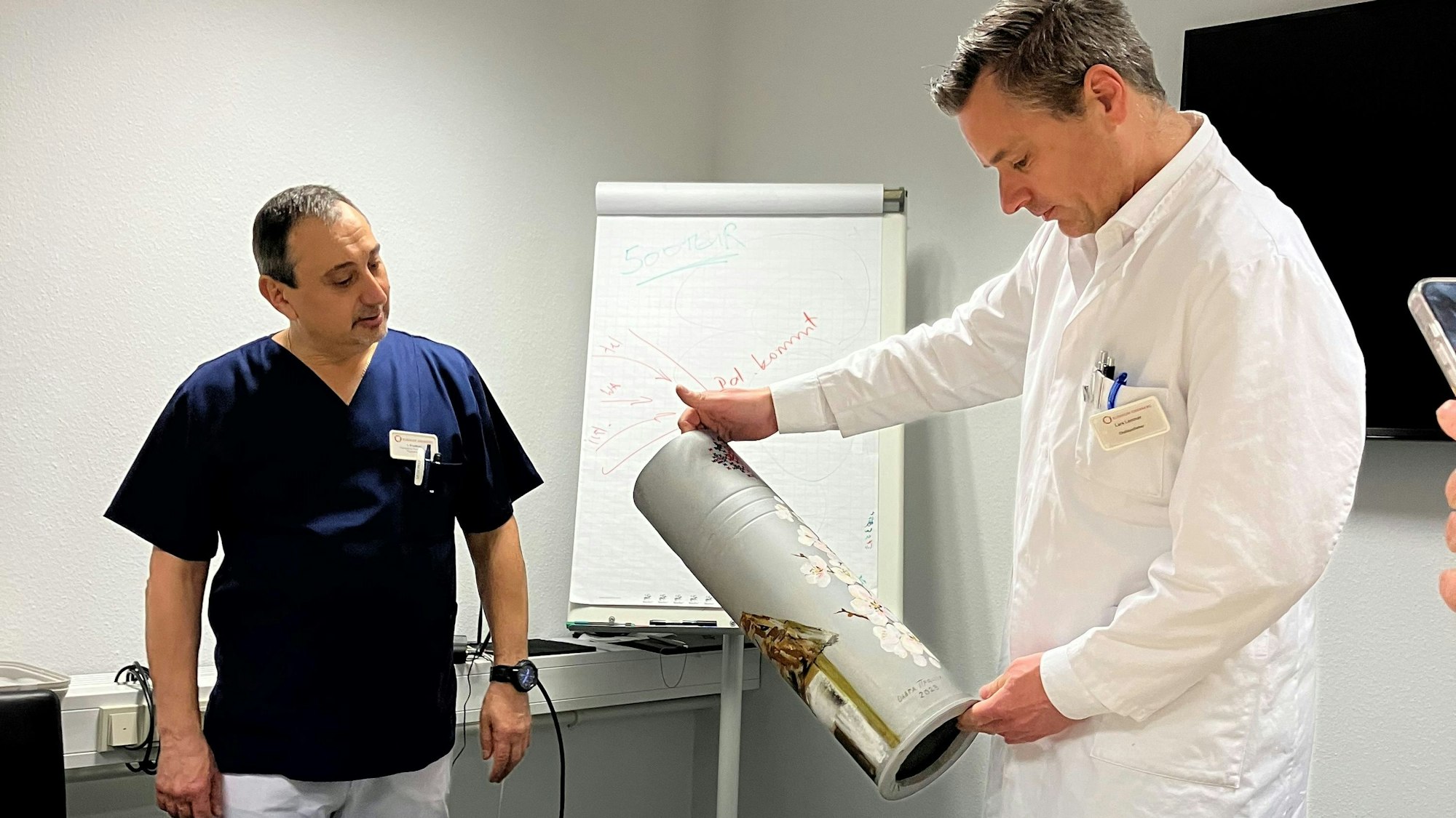 Igor Prudkov überreicht eine bemalte Granathülse unter anderem an Lars Lemmer, Chefapotheker des Klinikums Oberberg.