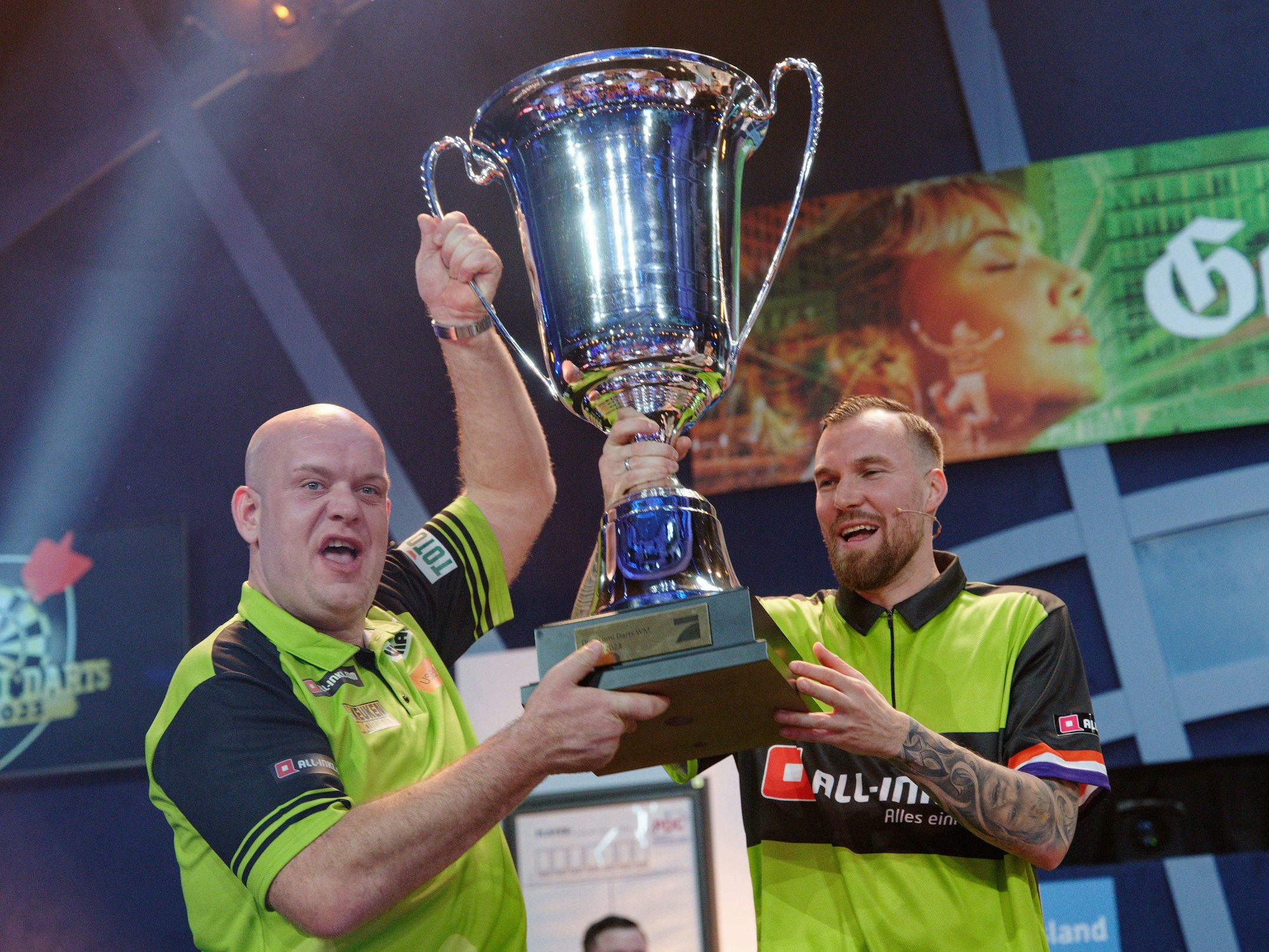 Der Fußballer Kevin Großkreutz (r) und der Dartprofi Michael van Gerwen freuen sich bei der ProSieben Promi-Darts-WM 2023 über ihren Sieg.
