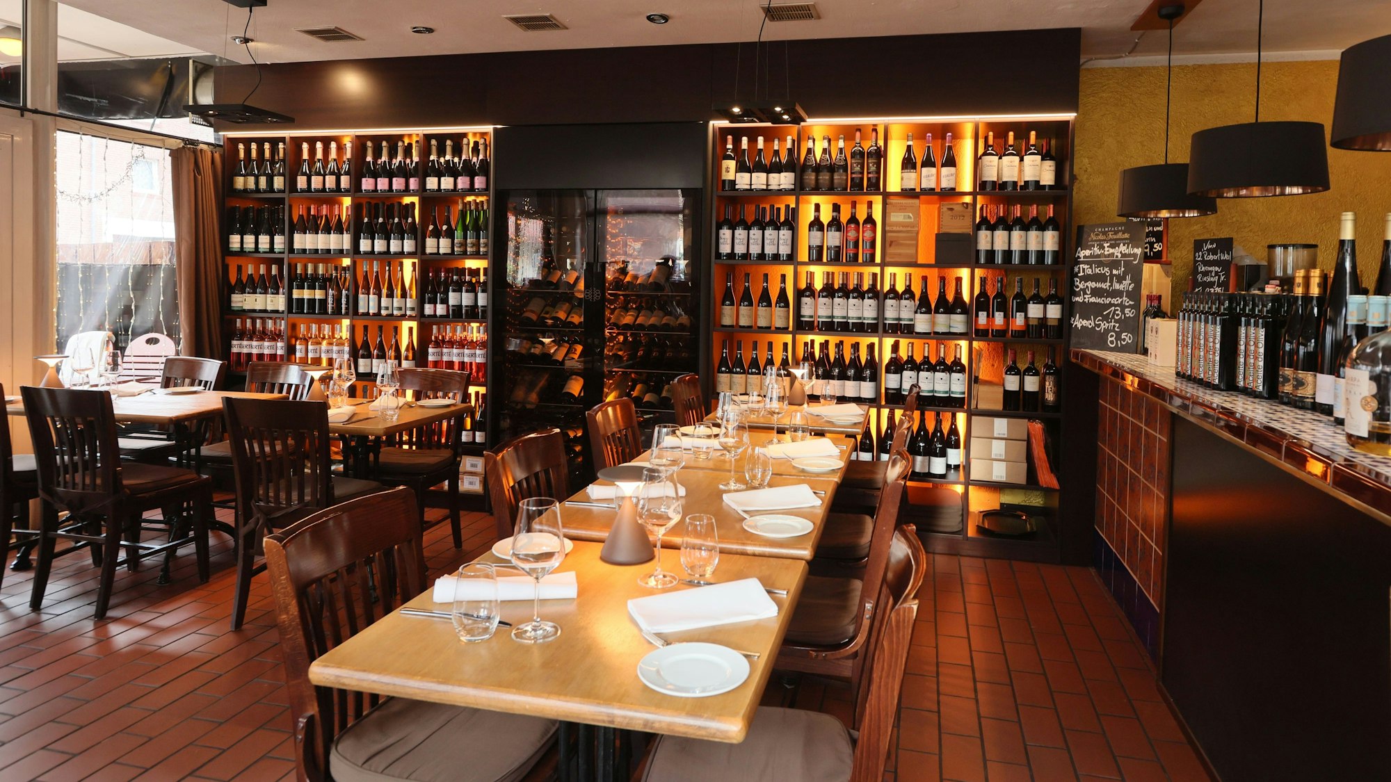 Lange Tische und Weinregale im Innenraum der Vinoteca