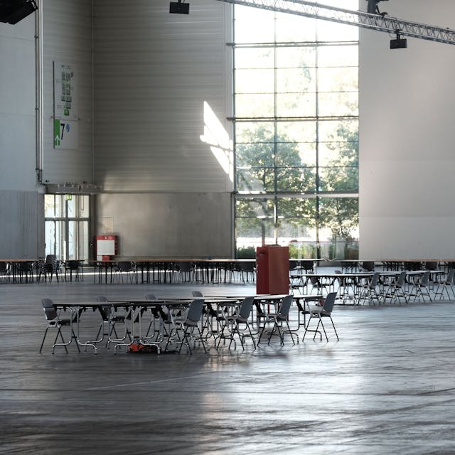 In einer ansonsten leeren Halle der Köln-Messe in Köln-Deutz stehen Stühle herum.