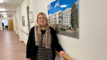 Petra Jennen vor einem Foto des Awo-Seniorenzentrums in Schlebusch
