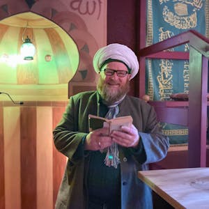 Ahmad Adamek trägt Gebetsmütze und Turban. Er liest in der osmanischen Herberge in Kall-Sötenich aus dem Koran.