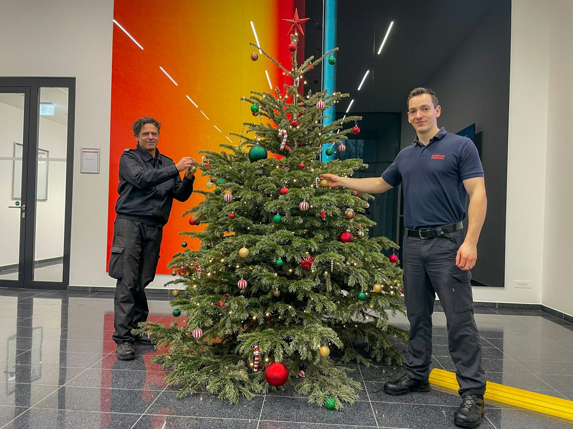 Stefan Gasch und Valentin Schäfer stehen an einem Weihnachtsbaum.