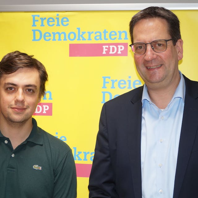 Frederik Schorn und Markus Herbrand stehen vor einem FDP-Banner.