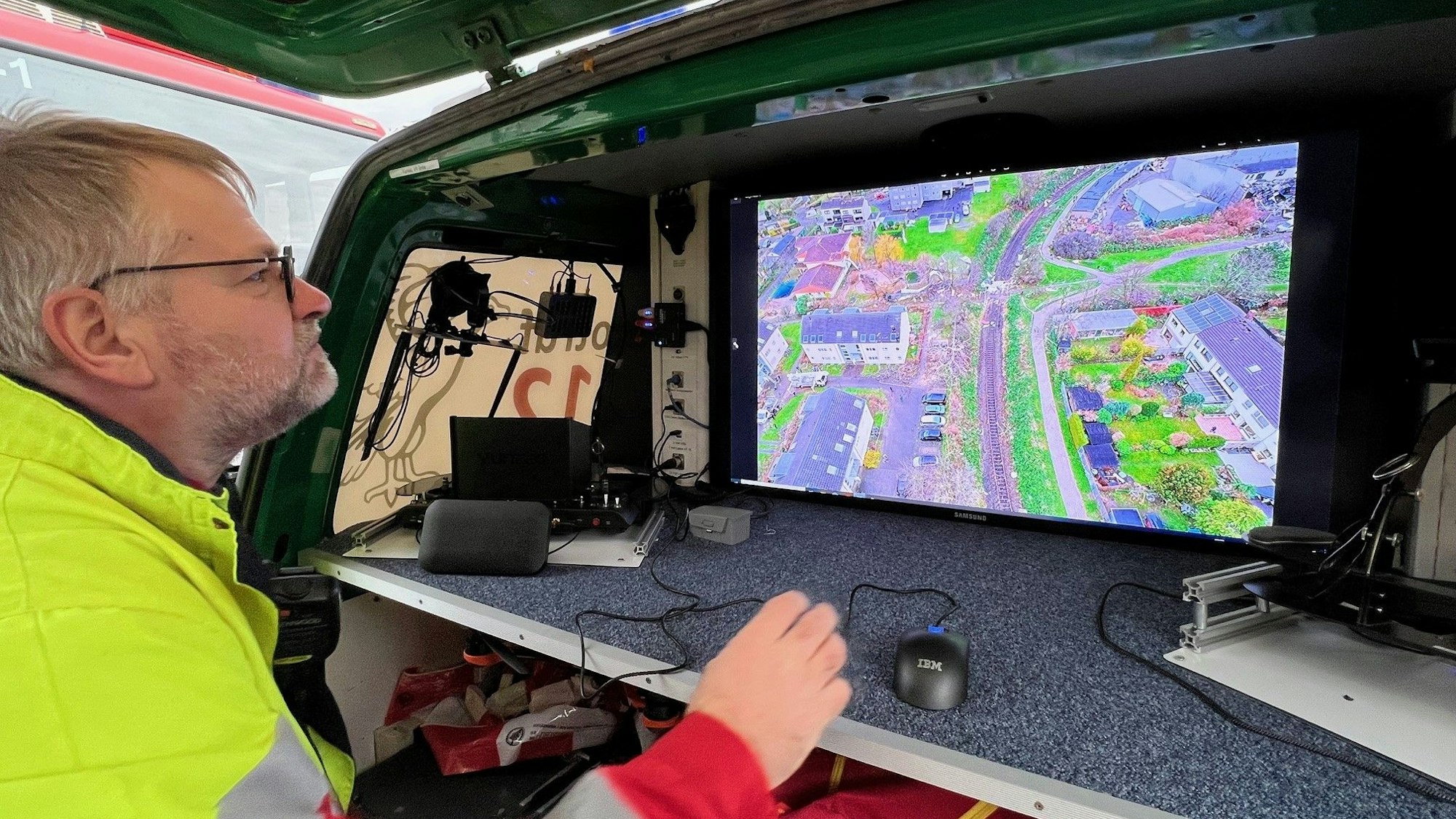 Ein DLRG-Mitarbeiter betrachtet die Luftaufnahmen einer Drohne über Poll, die Sturmschäden entlang der Alfred-Schütte-Allee filmt.