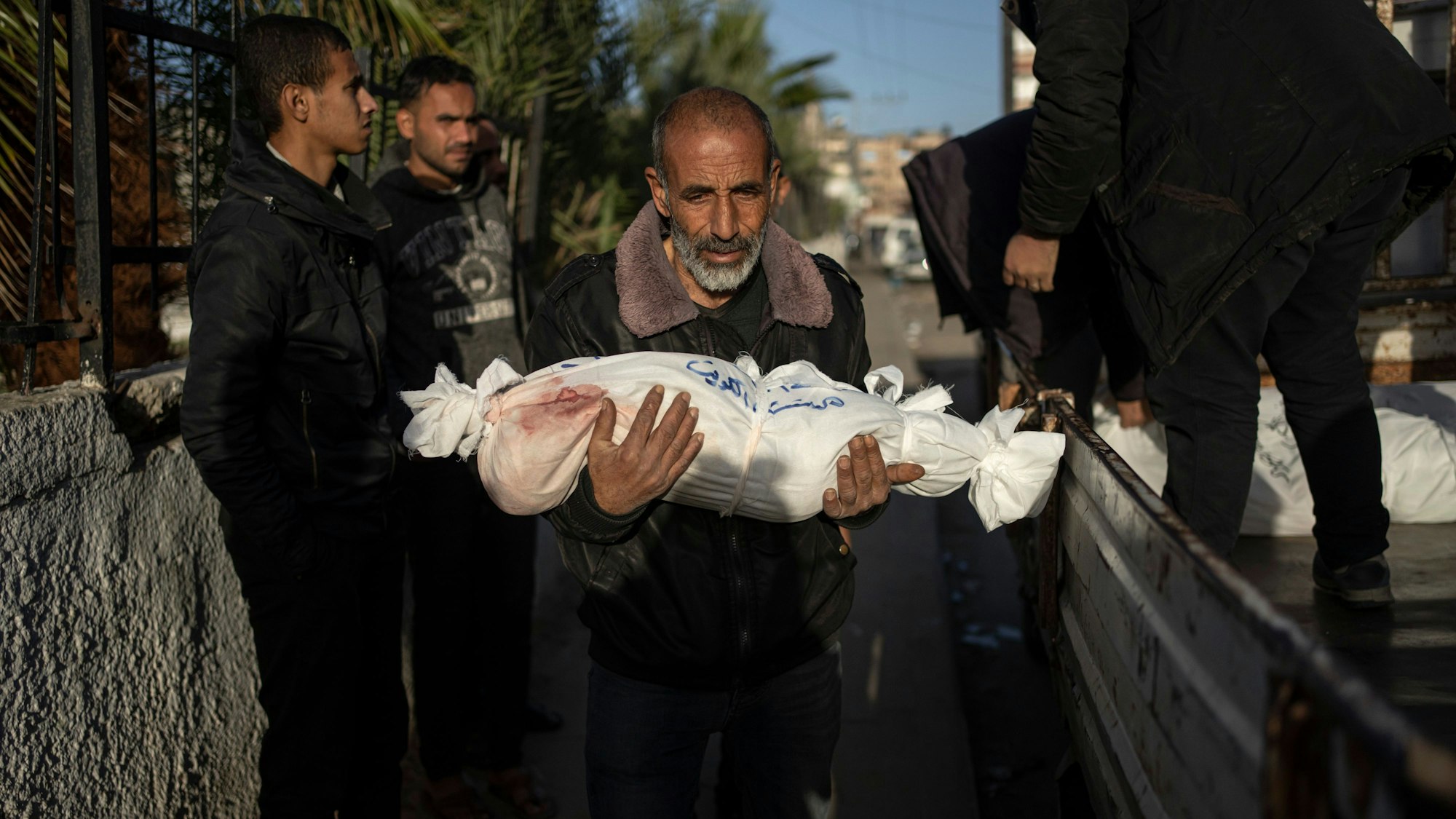 Ein Palästinenser trägt die Leiche seines Enkels, der im Süden von Gaza umgekommen ist.