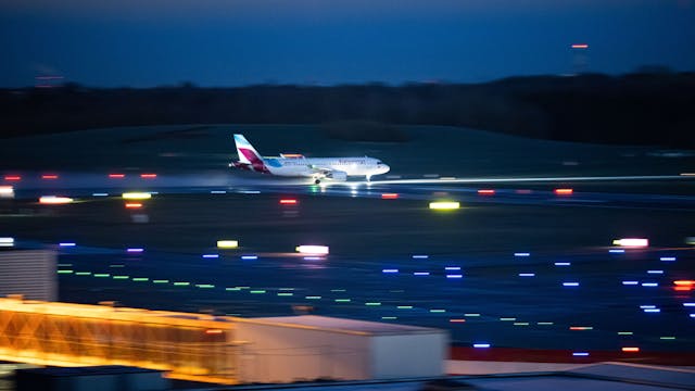 Ein Airbus A320 der deutschen Fluggesellschaft Eurowings landet auf einer beleuchteten Landebahn. Mehrere Warnleuchten sind aktiv. (Symbolbild)