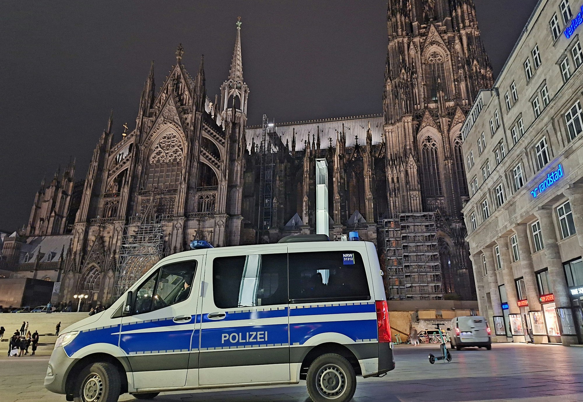 Ein Einsatzfahrzeug der Polizei steht vor dem Kölner Dom. Einen Tag vor Weihnachten erhöht die Polizei in Köln wegen möglichen Anschlagsplänen ihre Schutzmaßnahmen.