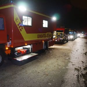 Mehrere Feuerwehrfahrzeuge stehen in der Dunkelheit auf einem Sammelplatz, von wo aus sie zu einem Einsatz im Ruhrgebiet aufbrechen.