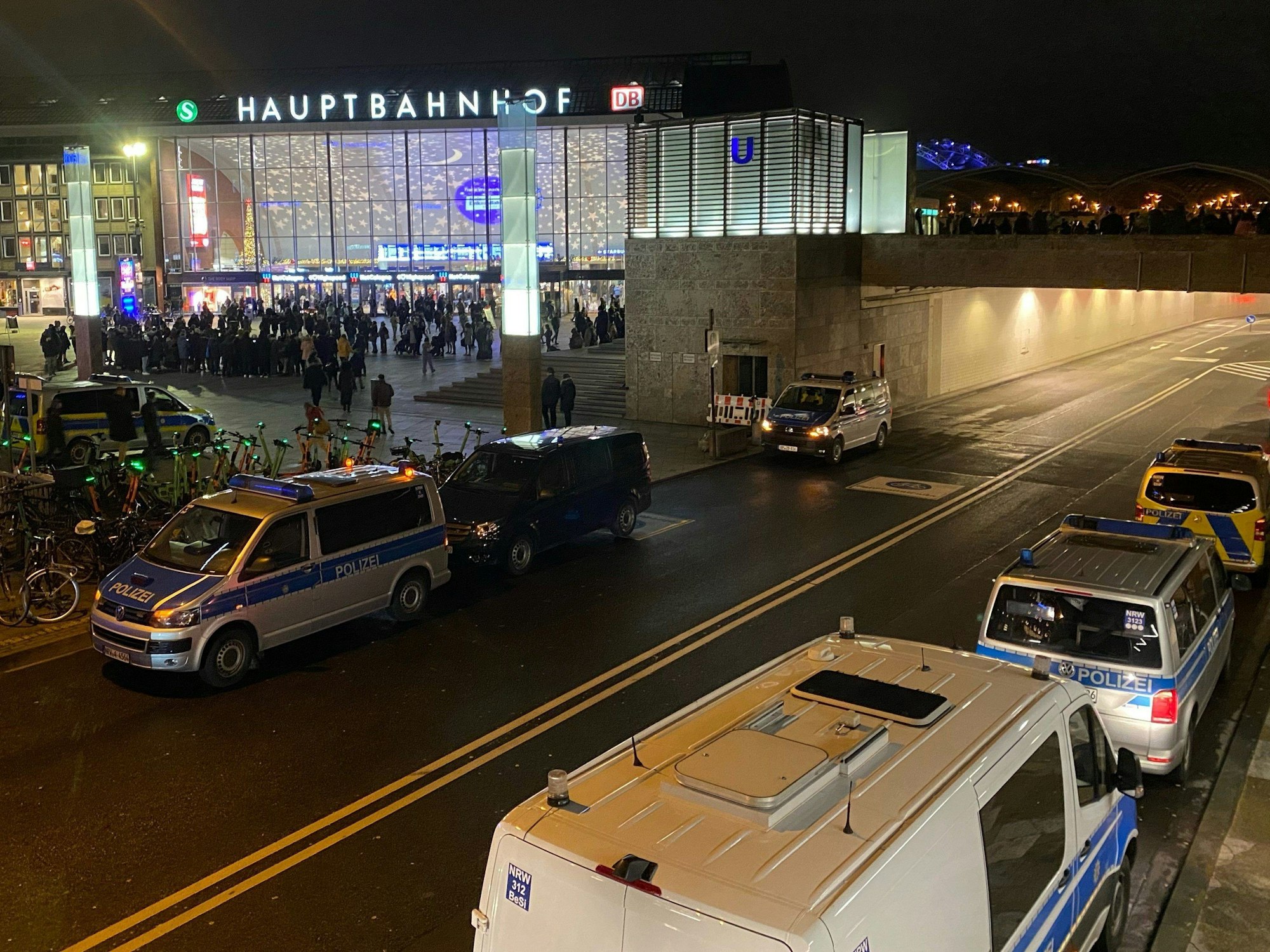 Polizisten und Einsatzfahrzeuge der Polizei stehen vor dem Hauptbahnhof.