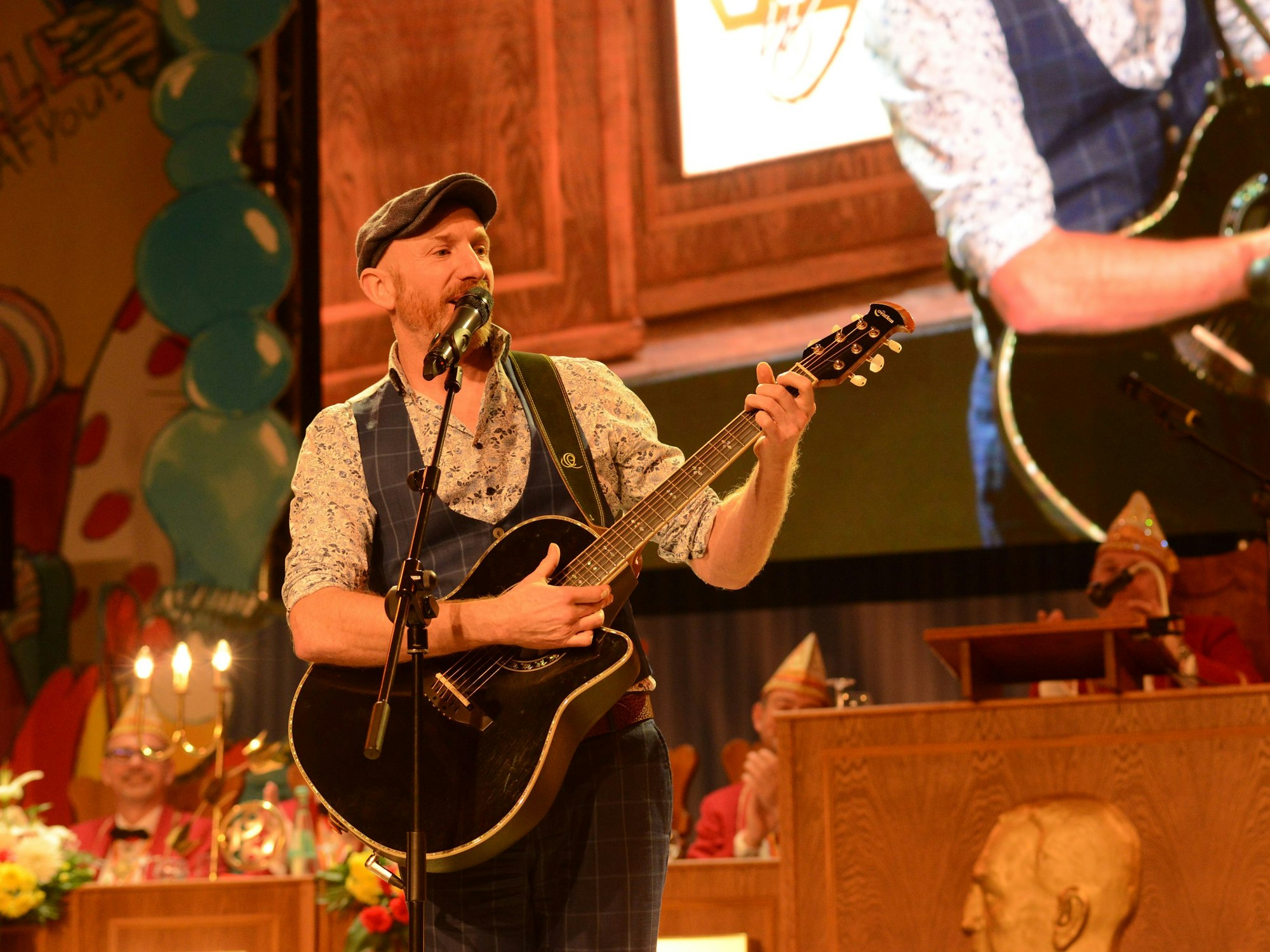 Martin Schopps mit Gitarre auf einer Bühne im Karneval.