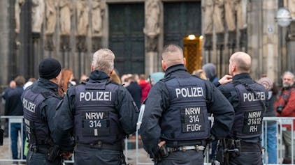 Polizisten stehen vor dem Kölner Dom.