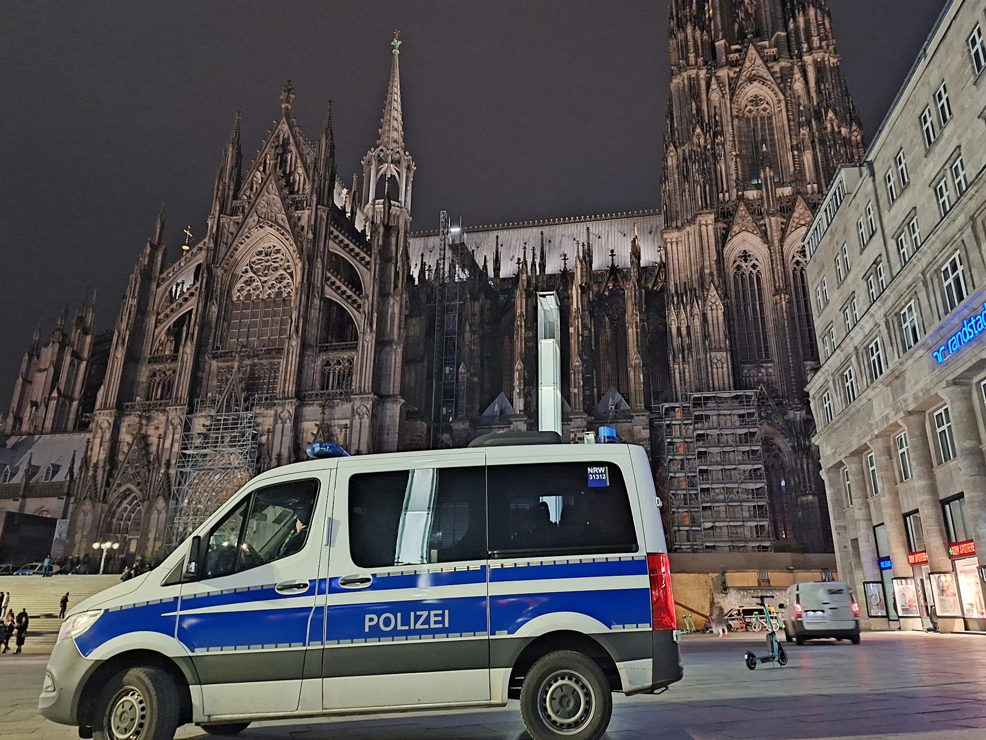 Ein Polizeiauto steht vor dem Kölner Dom.