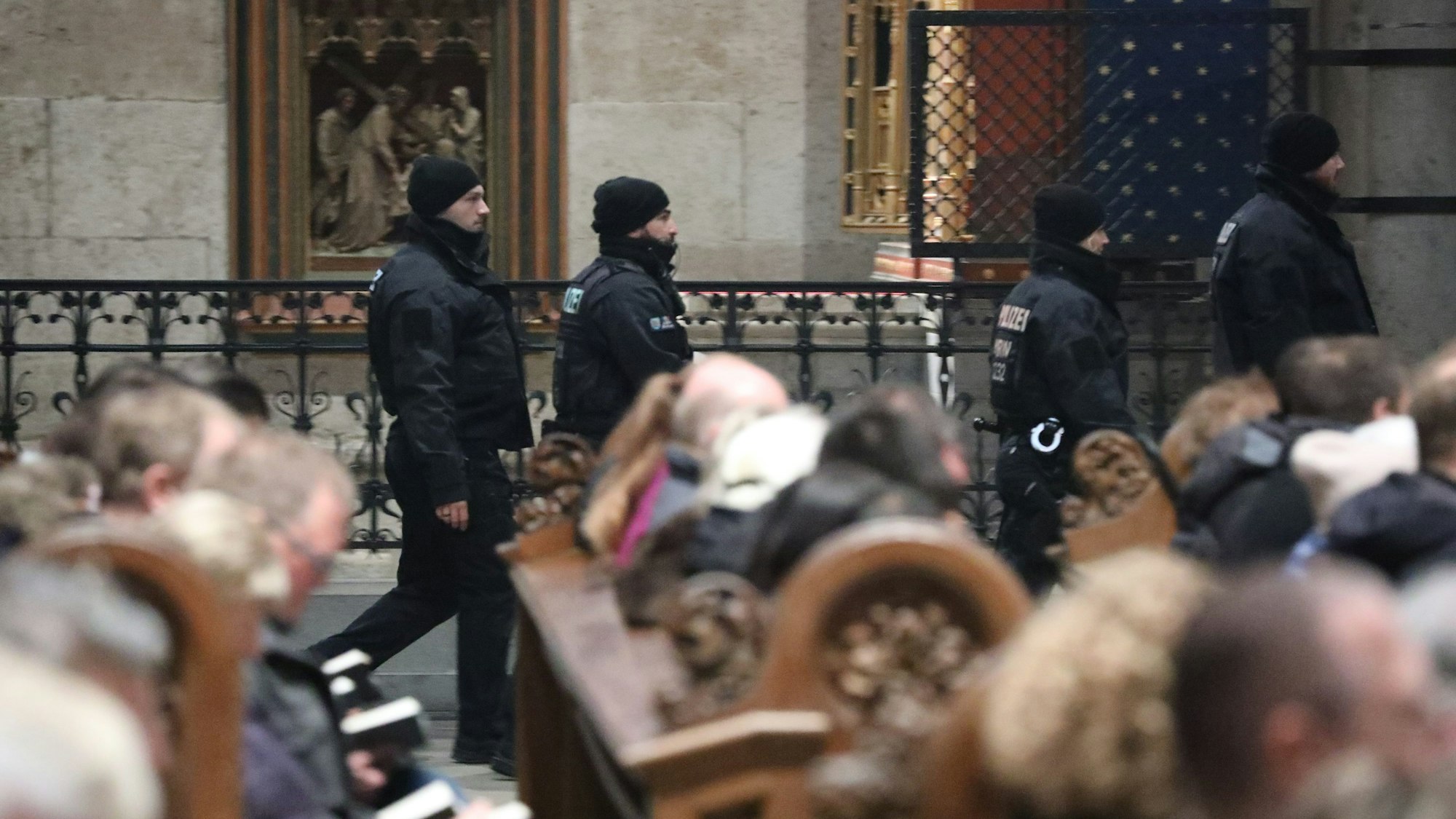 Polizisten laufen während des Pontifikalamtes durch den Kölner Dom.