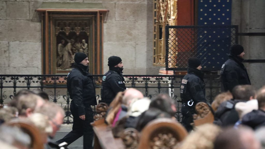 Polizisten laufen während des Pontifikalamtes durch den Kölner Dom.