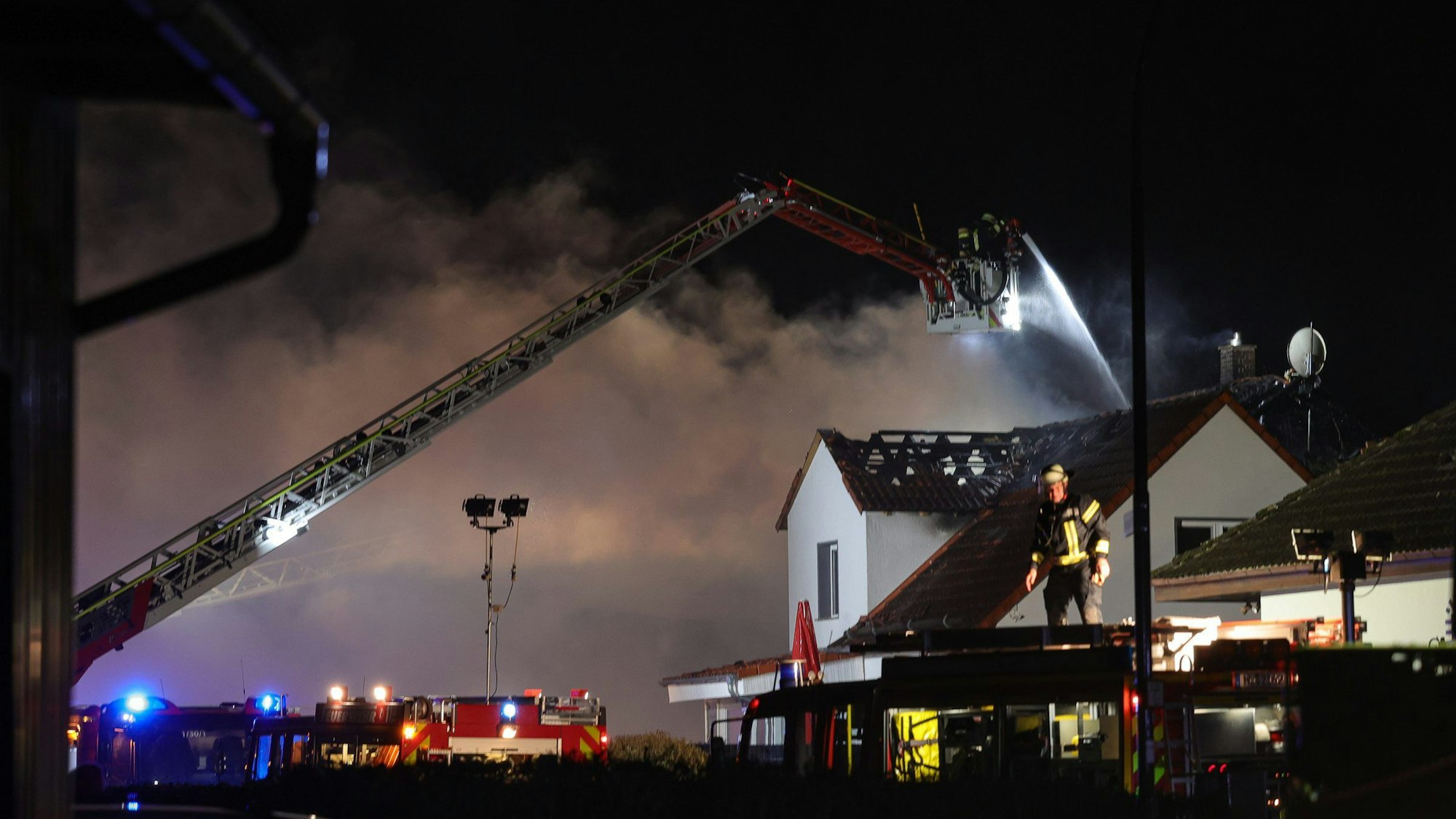 Einsatzkräfte der Feuerwehr löschen einen Wohnhausbrand im hessischen Wächtersbach. Es sind Hinweise auf Brandstiftung und ein rassistisches Motiv gefunden worden.