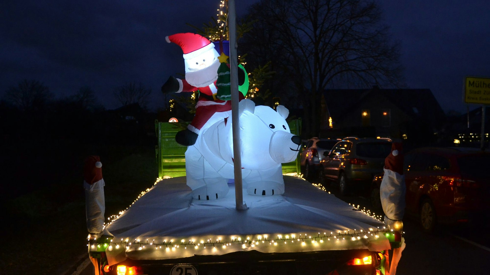 Ein Wagen zeigt aufgeblasene Figuren, die einen Weihnachtsmann und einen Eisbären darstellen.