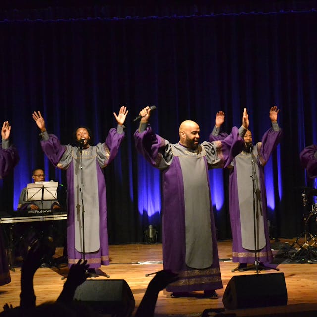 Das Ensemble der New York Gospel Stars steht mit erhobenen Armen auf der Bühne im Euskirchener Stadttheater und singt.