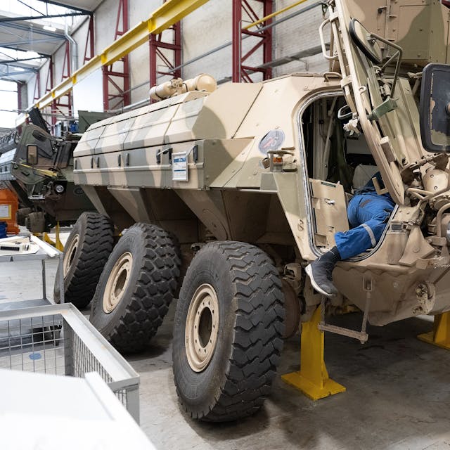 Ein Mitarbeiter von Rheinmetall arbeitet an einem Panzer vom Typ Fuchs in der Fertigungshalle von Rheinmetall in Kassel.