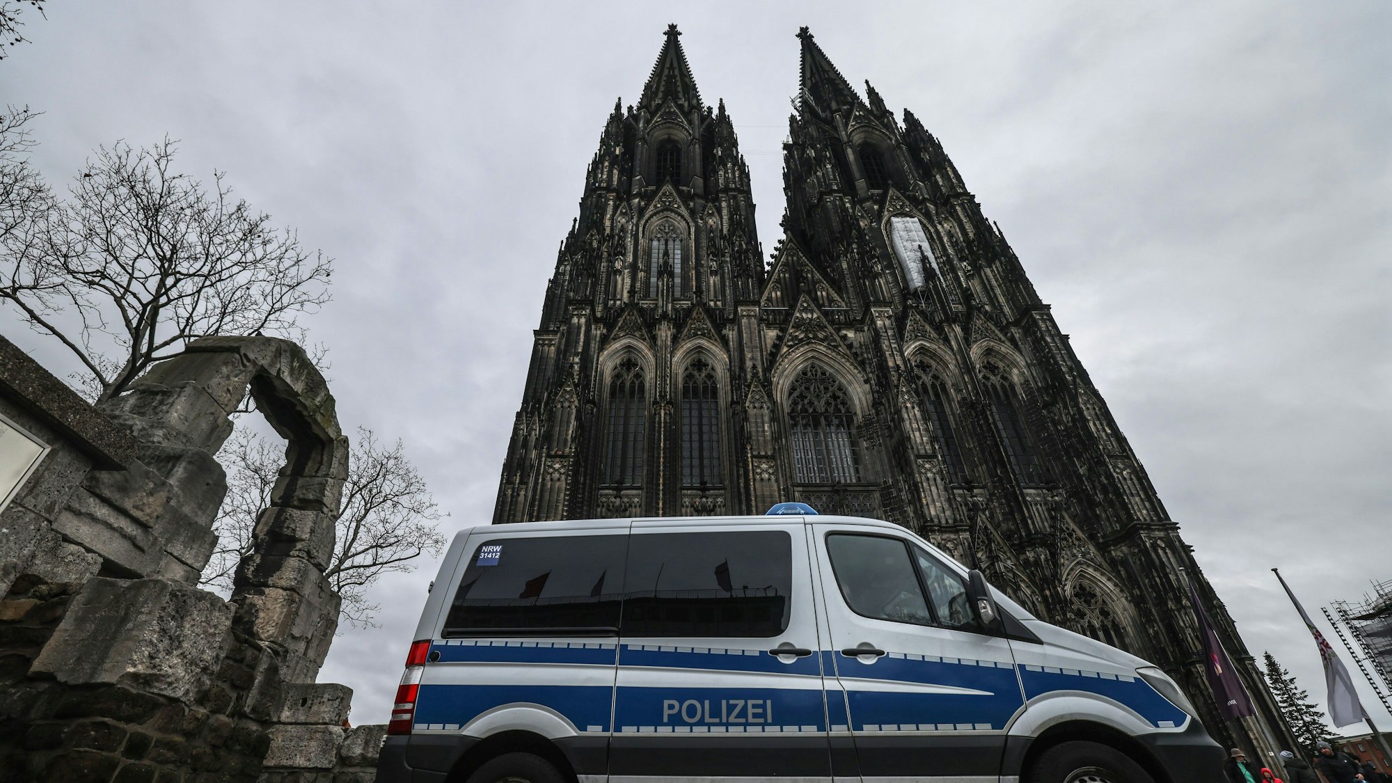 Ein Polizeifahrzeug steht vor dem Dom. Nach dem Terroralarm bleibt der Kölner Dom für Besucher geschlossen.