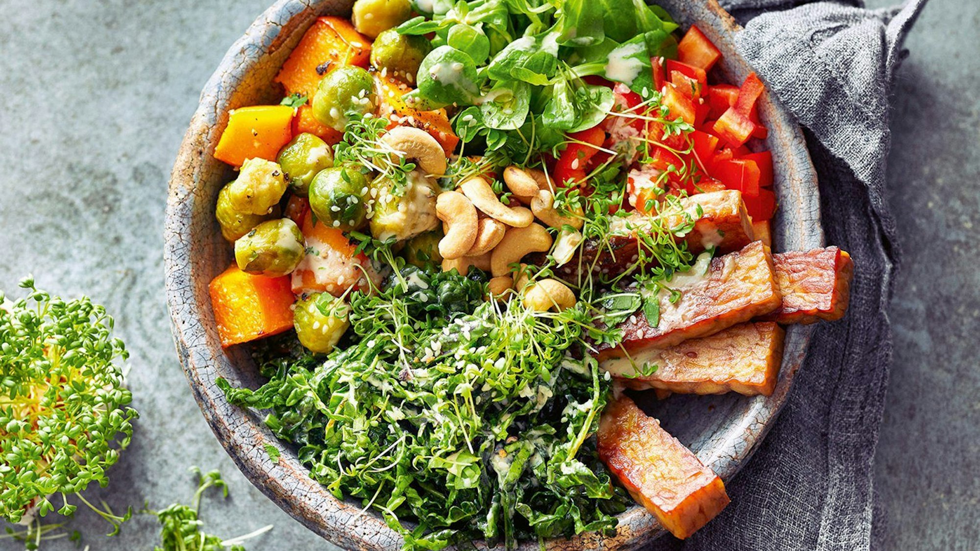 Bunte Bowl mit Ofengemüse, frischen Grünkohlblättern und gebratenem Tempeh. F