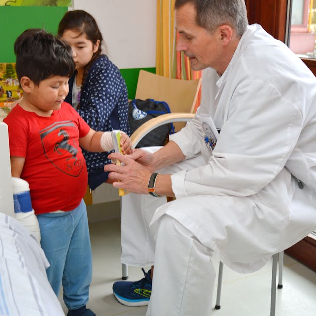 Das Foto zeigt einen Arzt und zwei Kinder
