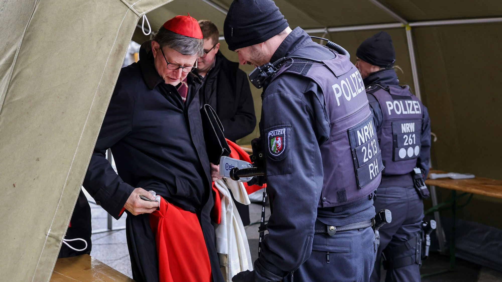 Kardinal Woelki bei einer Polizeikontrolle vor dem Kölner Dom.