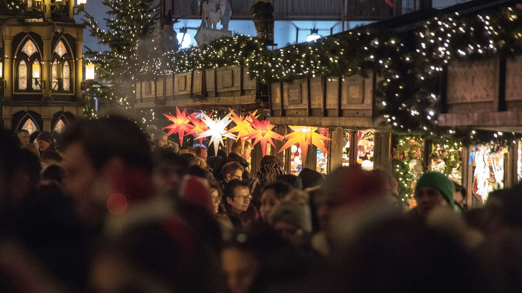 Menschen besuchen den Weihnachtsmarkt am Dom in Köln.