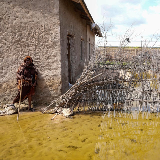 Abdia Sheikha Abdullahi, 70 Jahre alt, steht in Kenia im Hochwasser vor ihrem Haus. Im Oktober 2023 begannen die Regenfälle das Land zu überschwemmen.&nbsp; Ende November berief Kenias Präsident Ruto eine Dringlichkeitssitzung des Kabinetts ein und erklärte, dass 38 der 47 Bezirke Kenias von Überschwemmungen und Schlammlawinen betroffen seien, die durch das El-Niño-Phänomen noch verschlimmert worden seien.&nbsp;