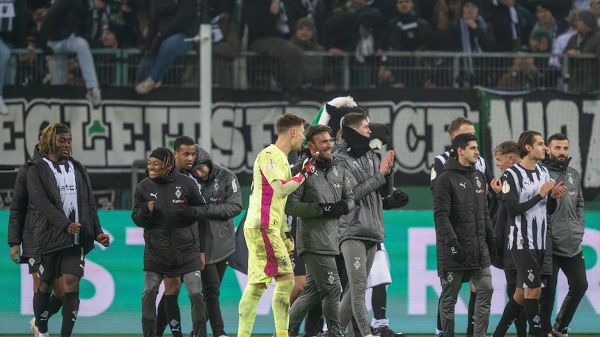 Spieler von Borussia Mönchengladbach feiern nach Spielende mit den Fans.