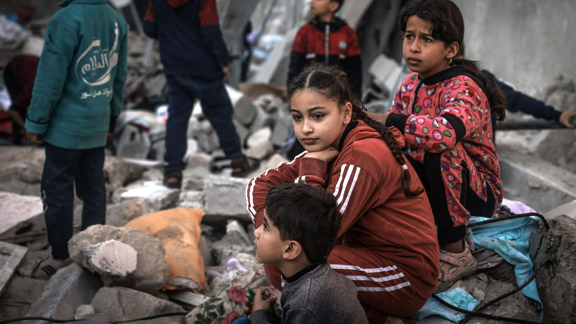 Children sit amid the rubble of destroyed buildings following Israeli bombardment in Rafah on the southern Gaza Strip on December 29, 2023, amid the ongoing battles between Israel and the Palestinian militant group hamas. (Photo by AFP)