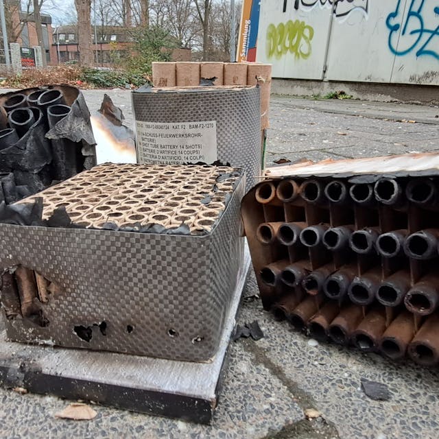 Abgebrannte Reste von Feuerwerkskörpern und Raketen liegen auf der Straße.