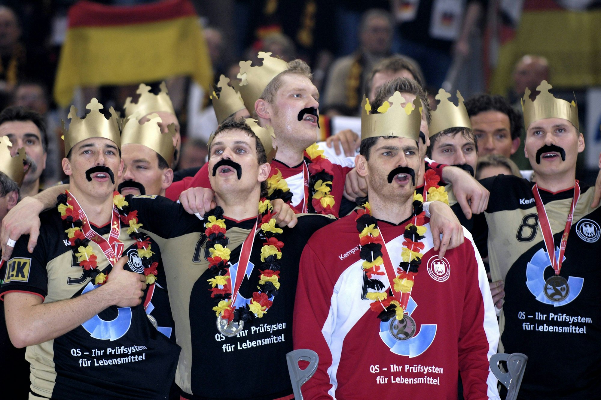 Dominik Klein, Michael Kraus und Henning Fritz feiern den WM-Titel mit Papp-Krone und Klebe-Schnauzbart.
