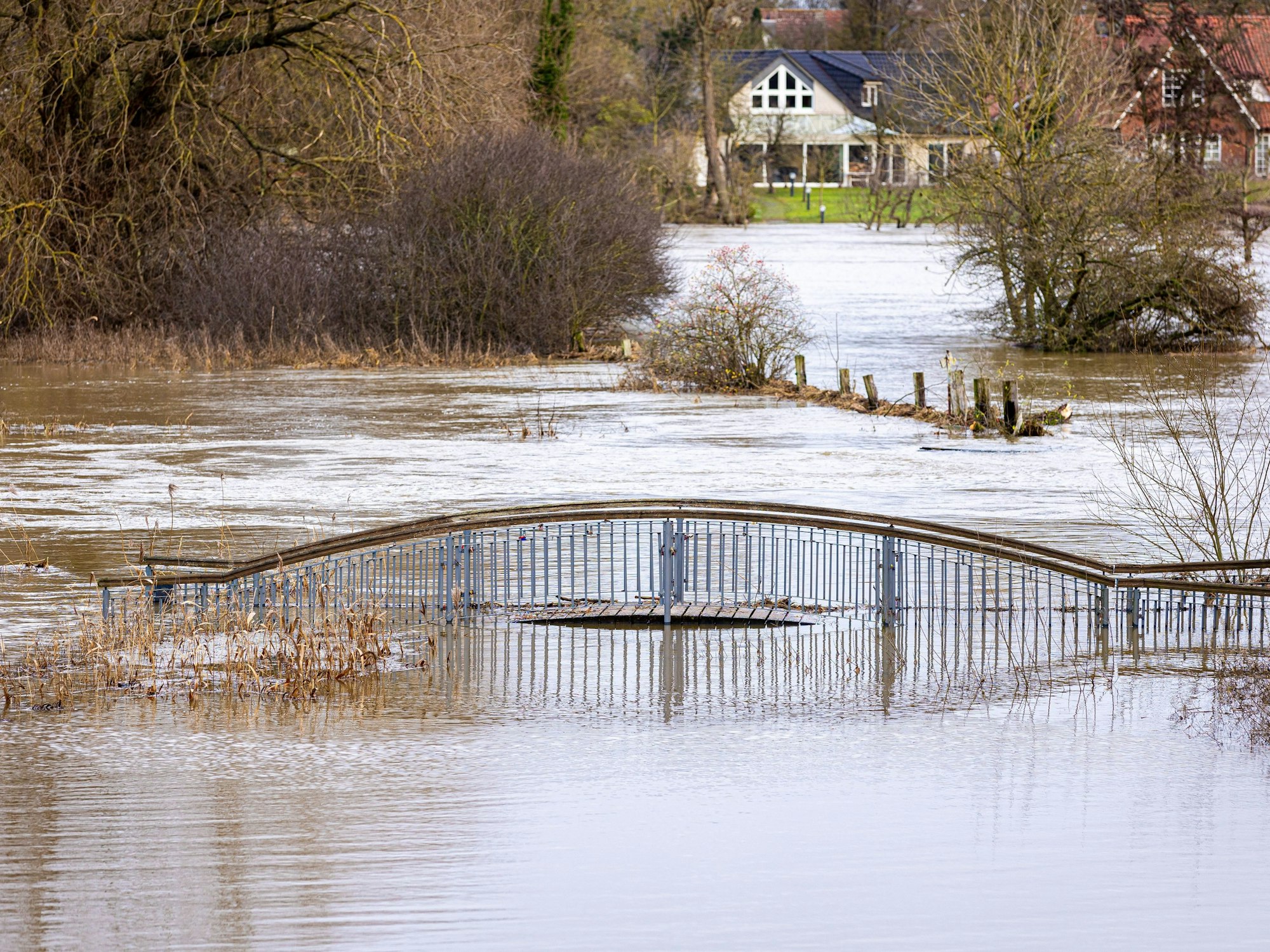 Eine Brücke ragt aus der Kleinen Leine, die Hochwasser führt, hier in Neustadt am Rübenberge in Niedersachsen.