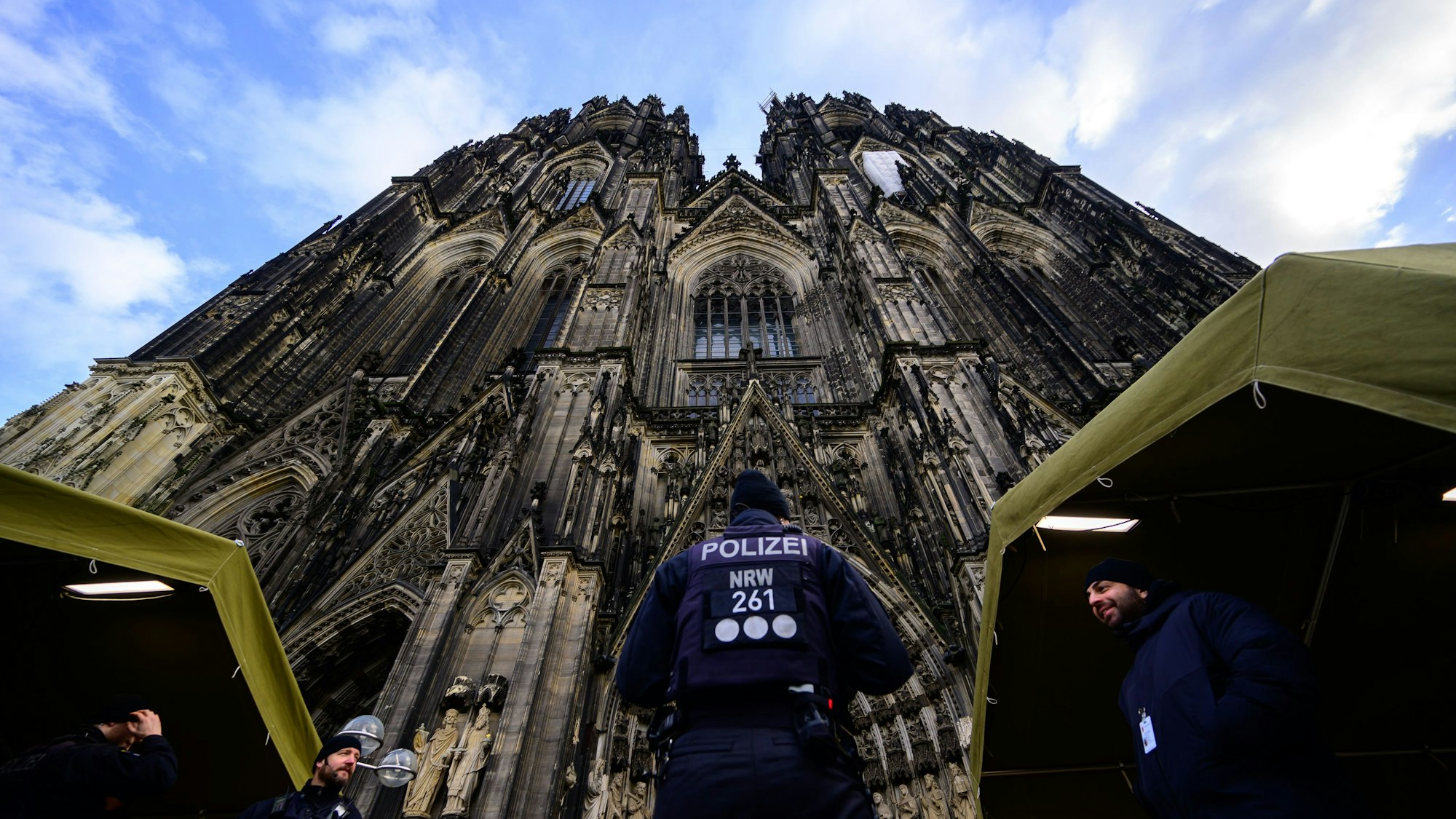 Ein Polizist steht vor dem Kölner Dom.
