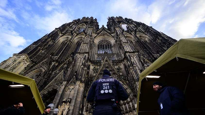 Ein Polizist steht vor dem Kölner Dom.