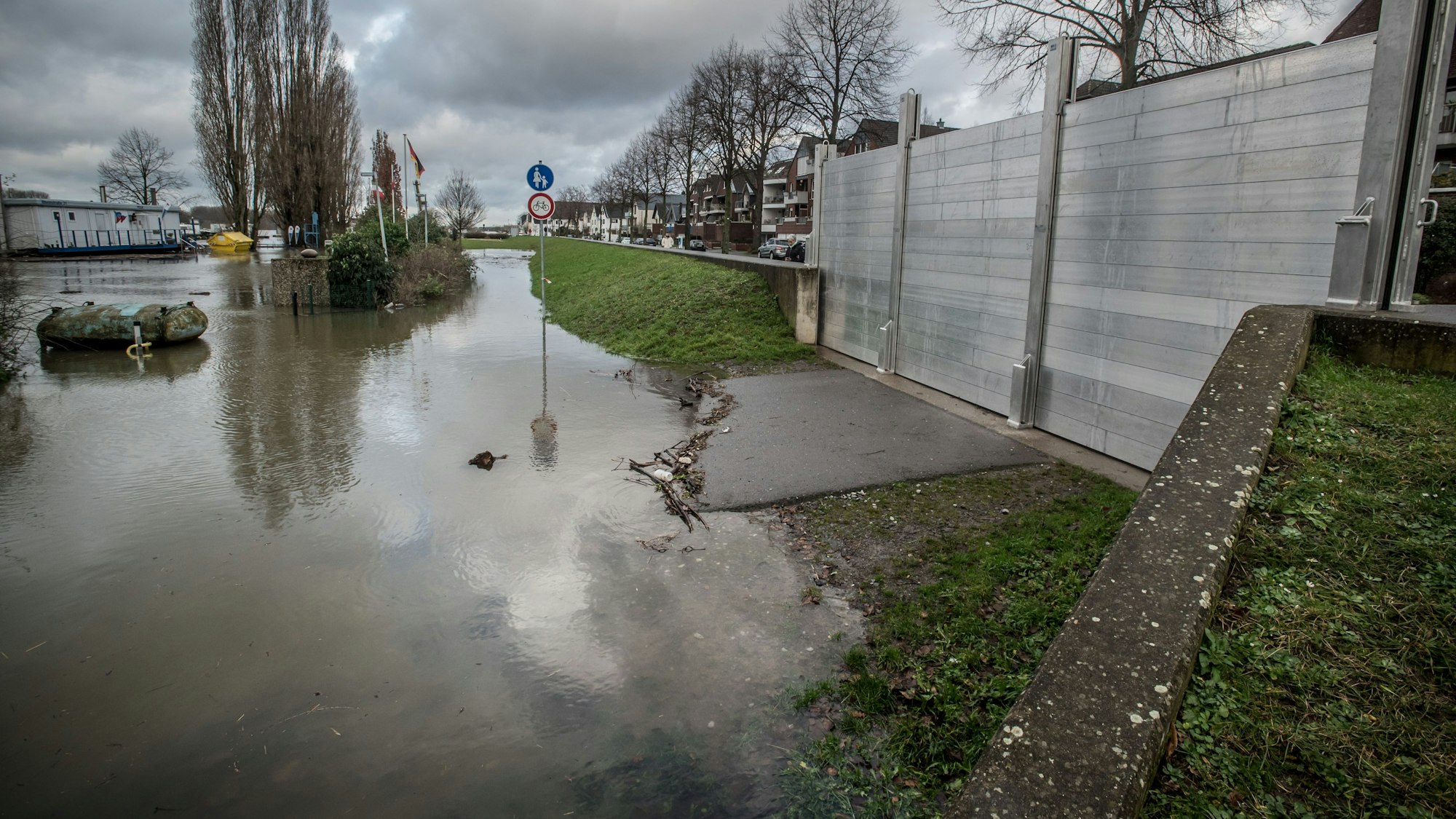 Das Hochwasser in Hitdorf steht knapp vor dem Tor am Hafen.