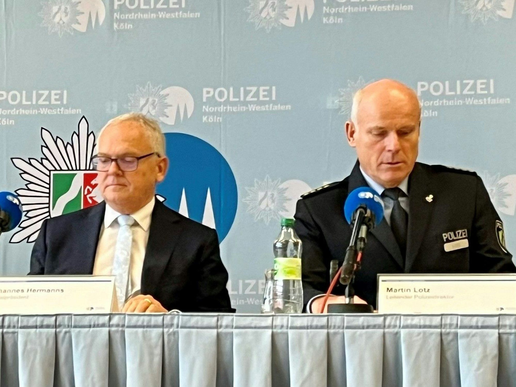 Kölns Polizeipräsident und der Leitende Polizeidirektor werfen vor Beginn der Pressekonferenz noch mal einen Blick in ihre Aufzeichnungen.