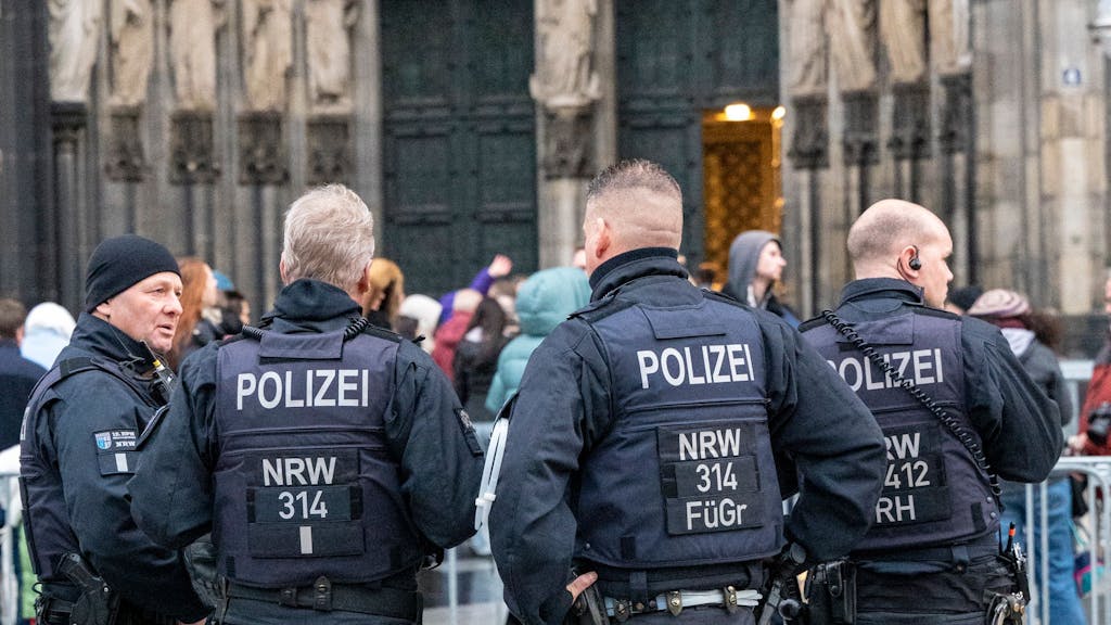 Vier Polizisten stehen an einem Absperrgitter am Kölner Dom.&nbsp;