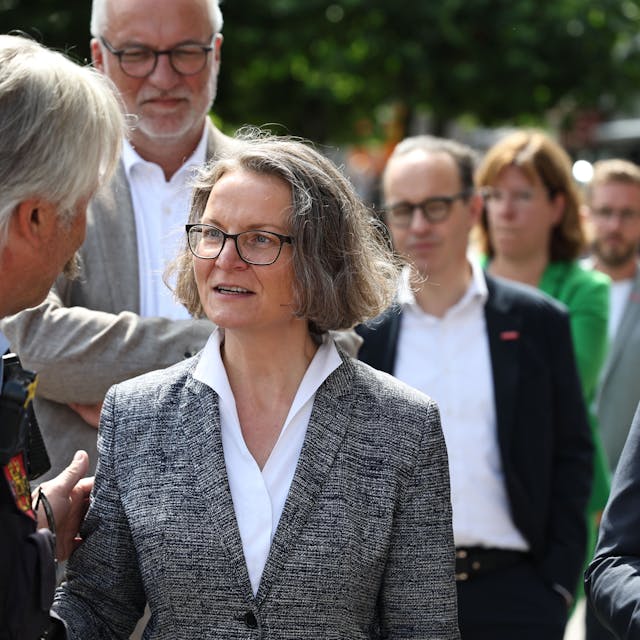 NRW-Heimatministerin Ina Scharrenbach spricht in Euskirchen mit einem Polizisten. Rechts ist Landrat Markus Ramers zu sehen.