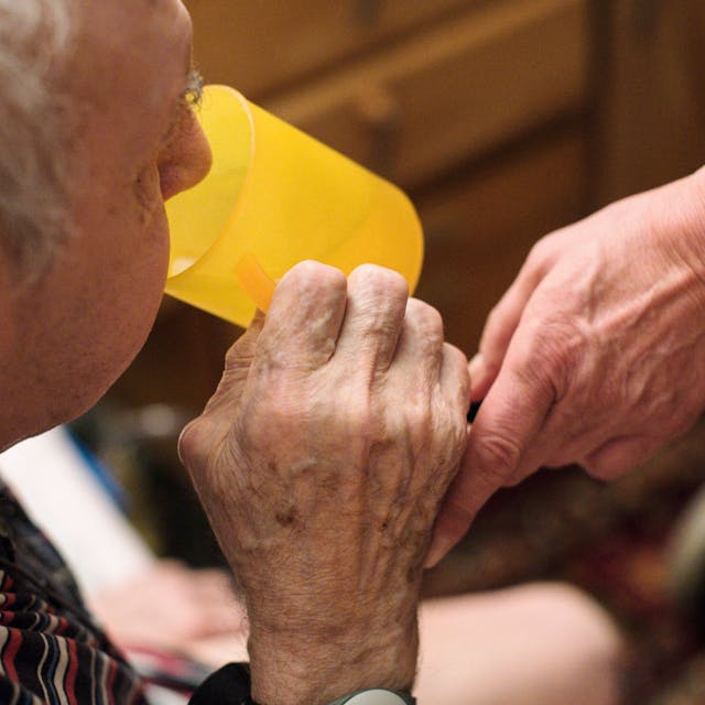 Eine ambulante Pflegerin hilft einem alten Mann bei der Tabletteneinnahme. (Symbolbild)
