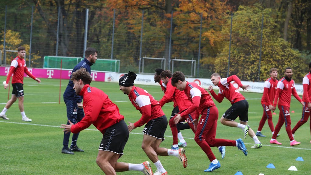 Die Profis des 1. FC Köln wärmen sich beim Training mit Sprint-Übungen auf.