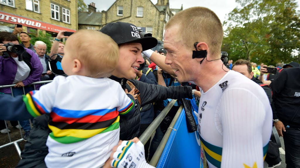 Rad-Star Rohan Dennis umarmt seine Frau und seinen Sohn nach einem Radrennen.
