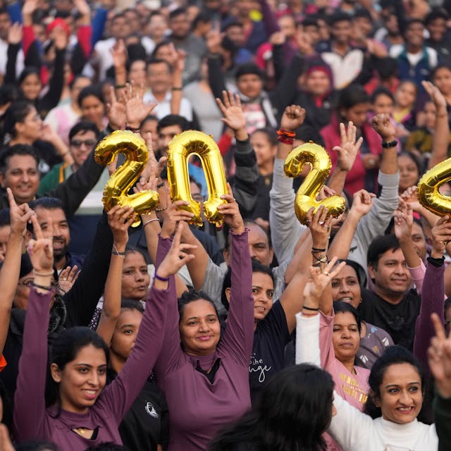 Menschen halten die Zahl 2024 und jubeln während einer Veranstaltung zur Verabschiedung des Jahres 2023 und zur Begrüßung des neuen Jahres in Ahmedabad (Indien).