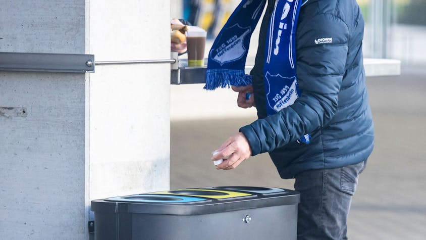 &nbsp;Ein Fan der TSG 1899 Hoffenheim wirft vor dem Spiel in einen Mülleimer. In der PreZero Arena wird ab sofort der Müll in verschiedenen Tonnen getrennt.