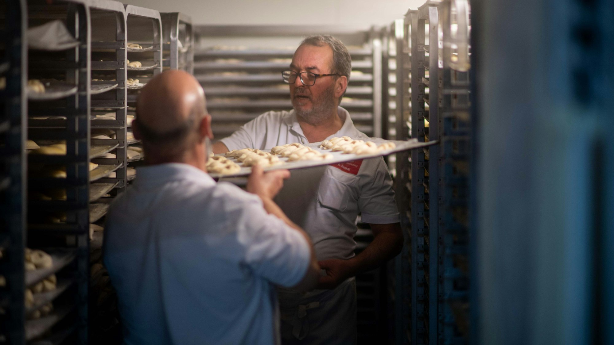 Das Bild zwei Mitarbeiter der Bäckerei Lennartz in einem Tiefkühlhaus.