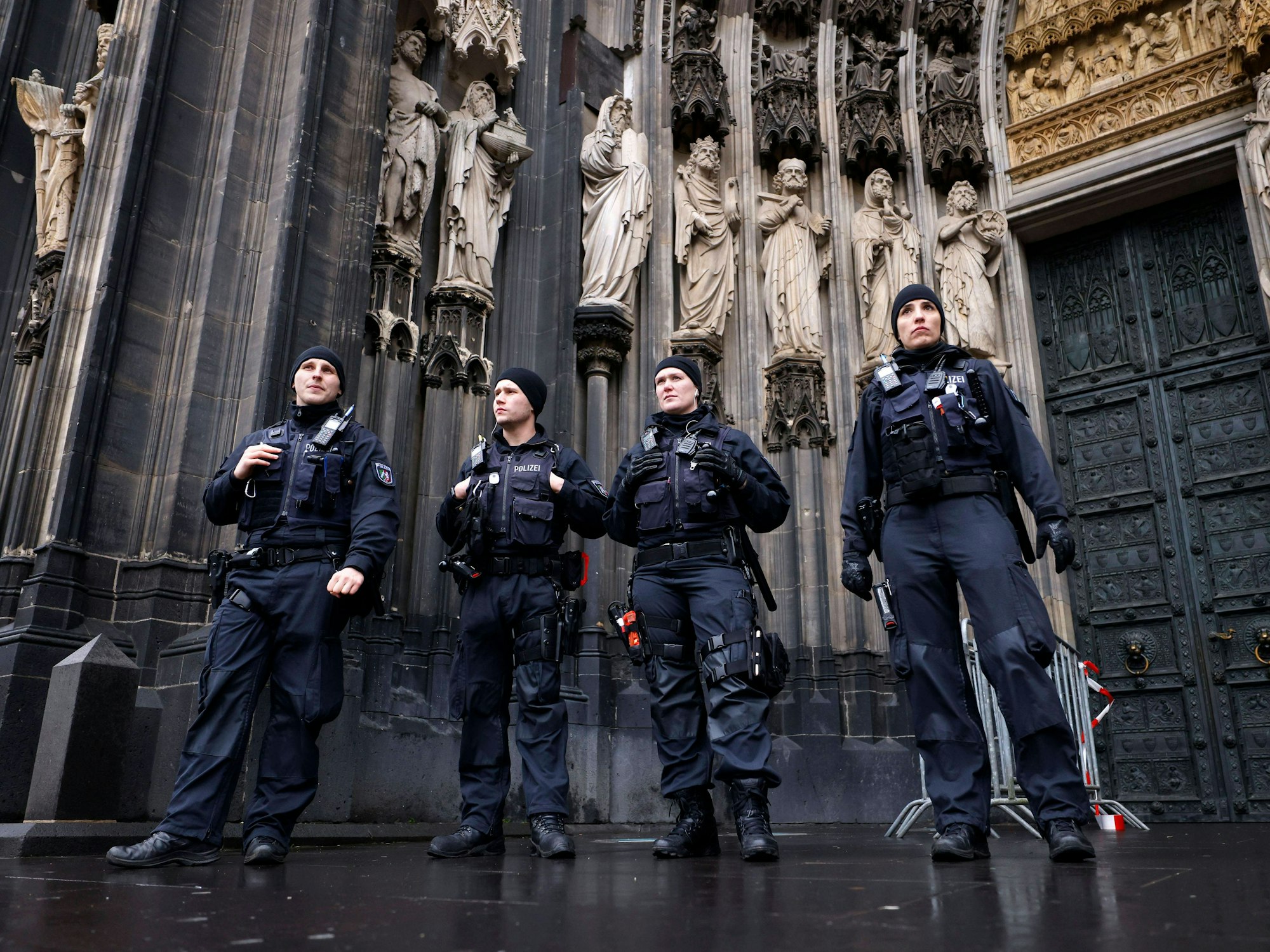 Polizeibeamte stehen vor dem Kölner Dom.