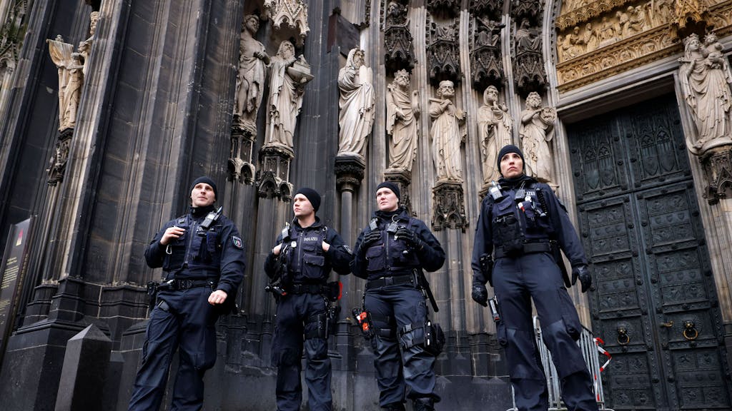 Polizeibeamte stehen vor dem Kölner Dom.