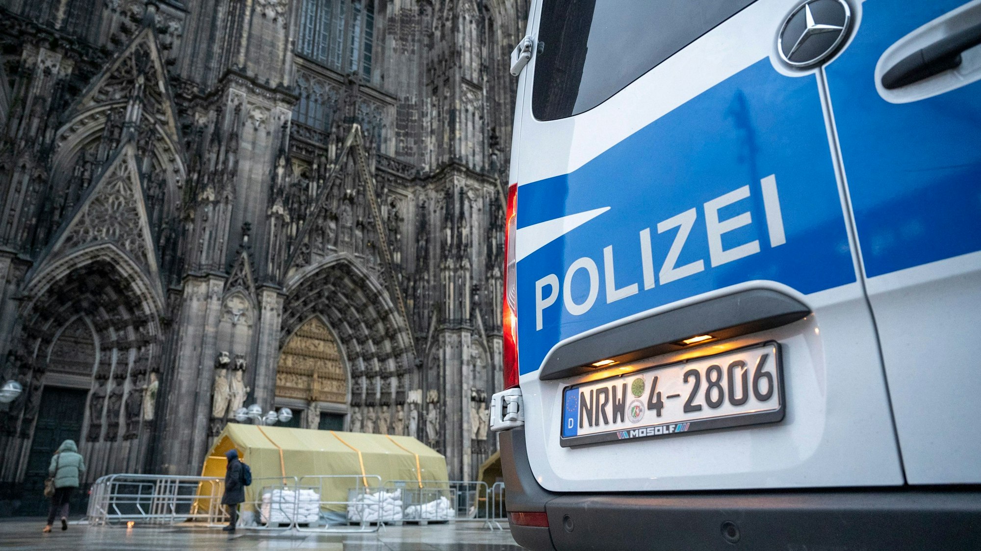 Ein Polizeiwagen steht vor dem Kölner Dom.