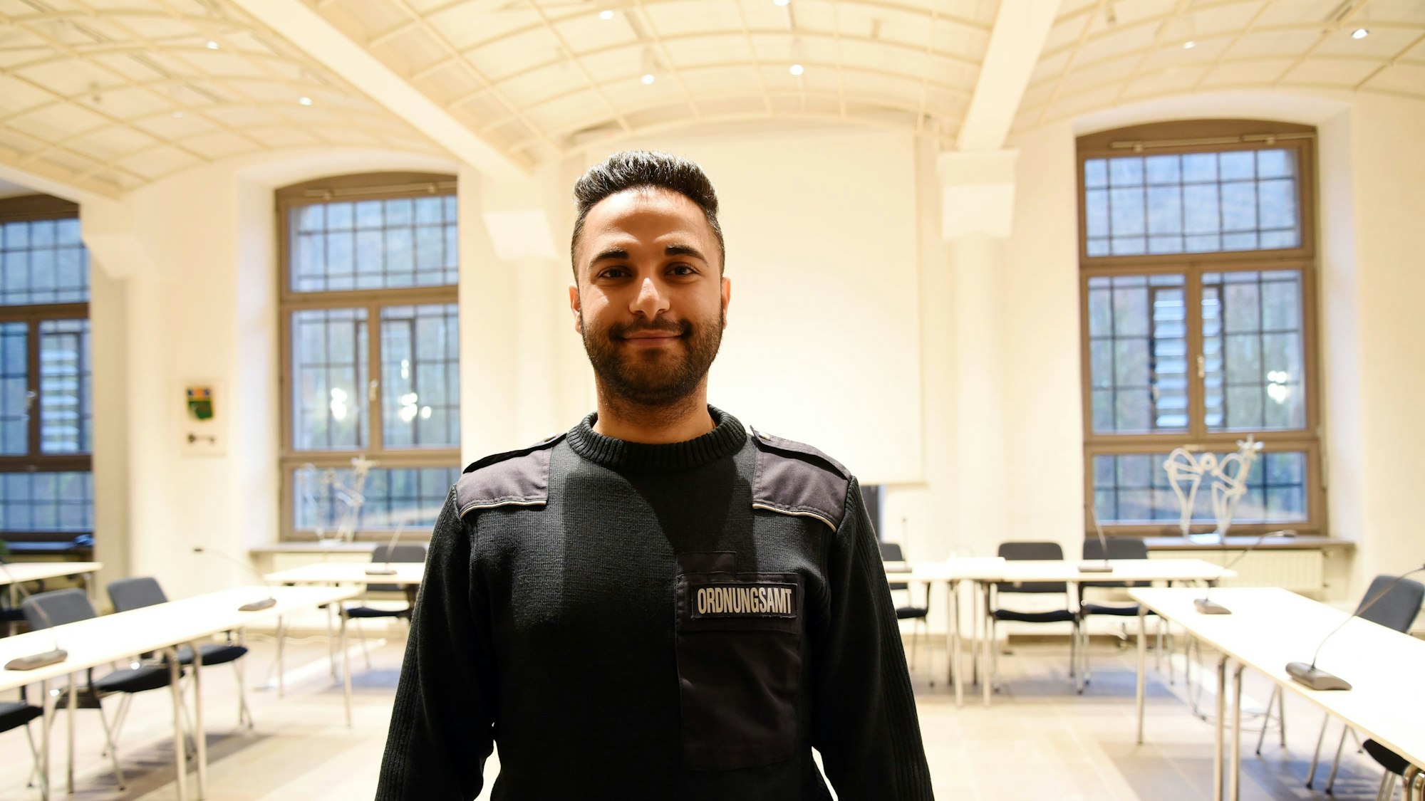 Der neue Mitarbeiter des Ordnungsamtes im Rathaus in Engelskirchen ist Mahmoud Yakni, hier steht er in Uniform im Ratssaal.